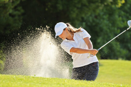 Golfer hitting the ball out of the bunker